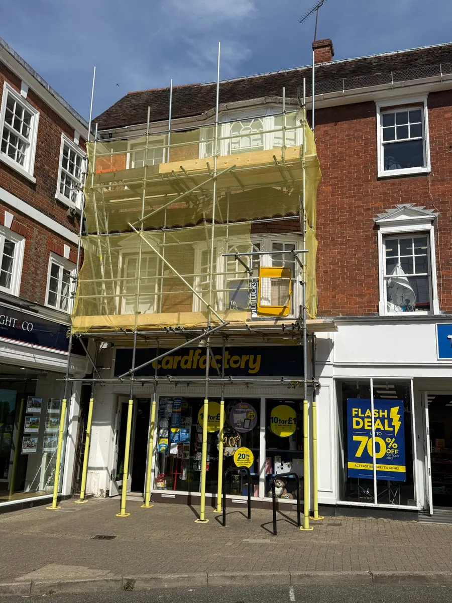 Commercial scaffold with debris netting on a high street shop