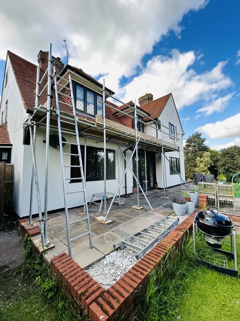 Roof-edge protection scaffold on a rendered house