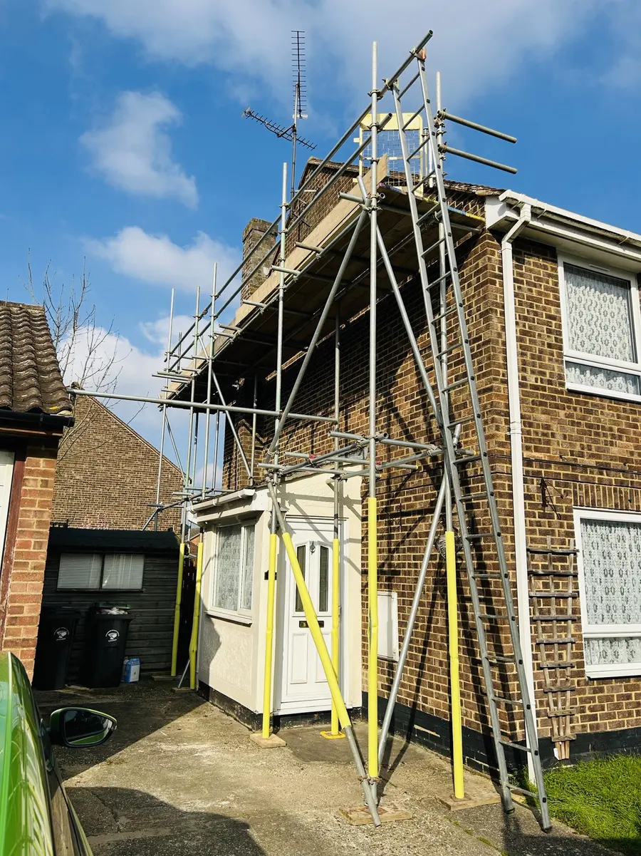 Domestic scaffold with yellow pole protection beside a front door